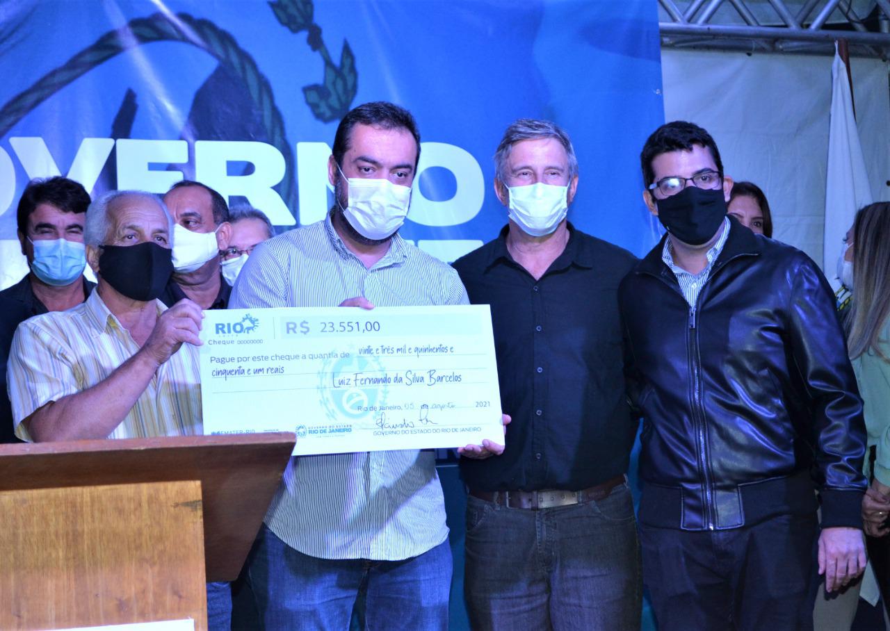 Imagem do Governador Cláudio Castro e do Secretário Marcelo Queiroz entregando cheques simbólicos em Quissamã