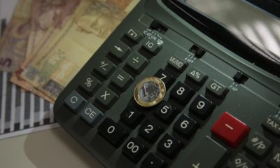 Imagem de calculadora notas e uma moeda
