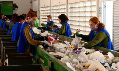 Imagem de pessoas separando material para reciclagem