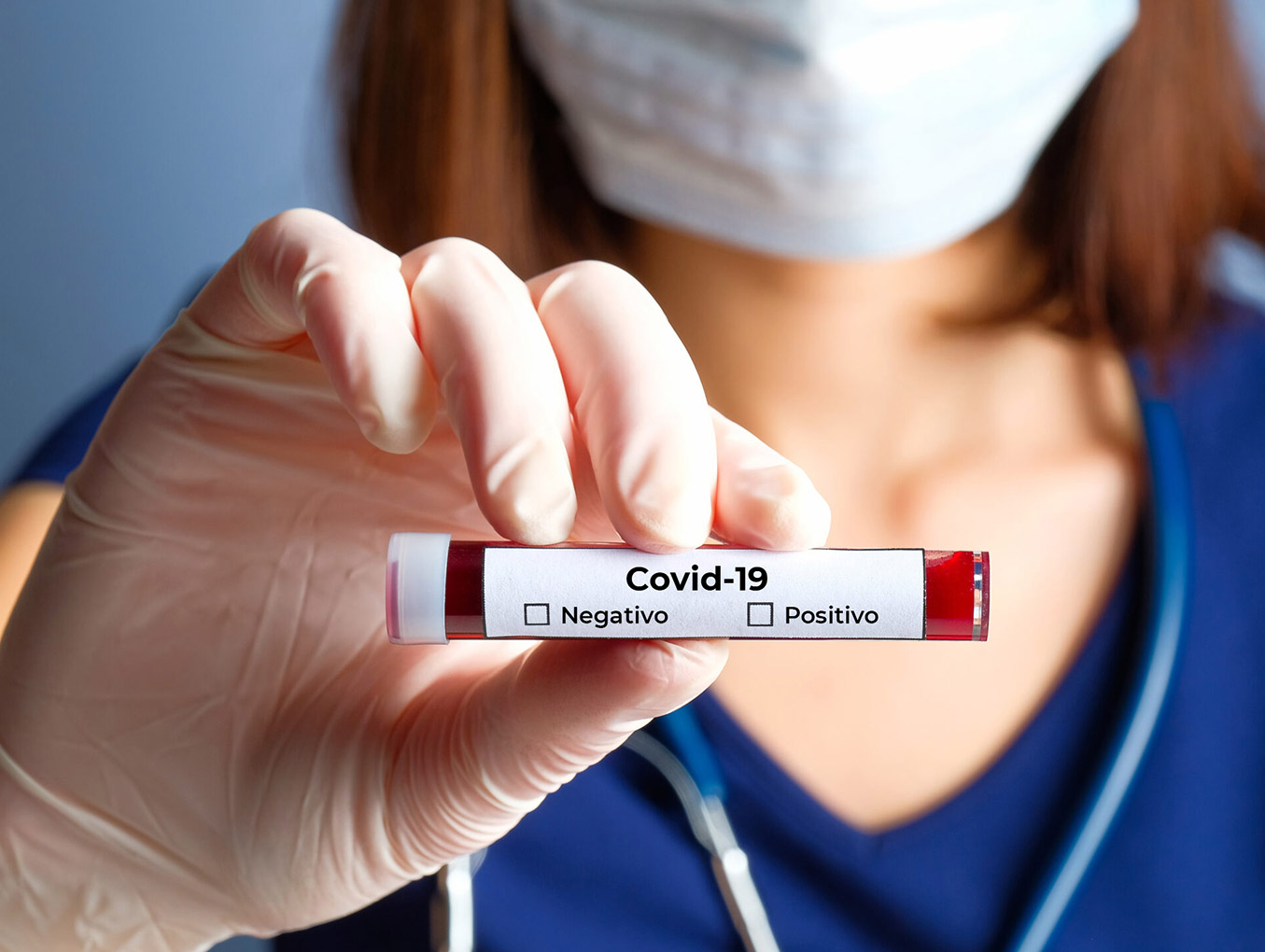 Enfermeira segura um tubo de ensaio com sangue coletado para examinar contaminação por Covid-19