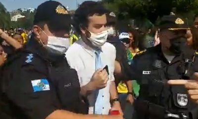 Repórter Pedro Duran sendo escoltado por PMs